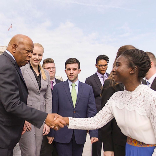 A student meets Rep. John Lewis on the steps of the U.S. Capitol 