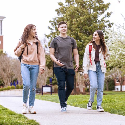 Three students walking through campus