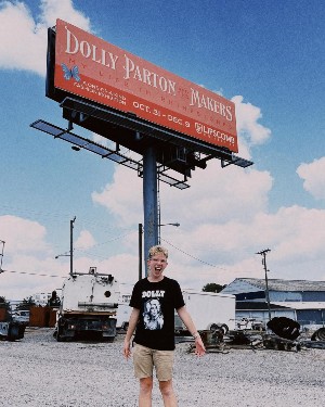 Sean Worth standing in front of the billboard he created