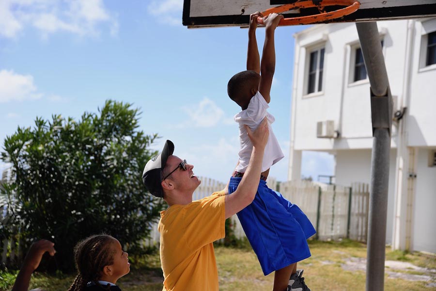 There are many opportunities for you to serve your community and world. Here, one of our students on mission in Saba gives a lift to a young friend during a game of basketball. 
