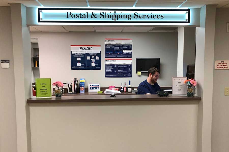 Shipping window at the Lipscomb Post Office with worker at counter.