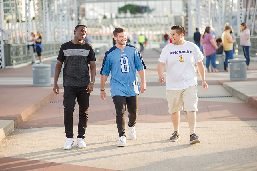 Three students walk together to a game in Nashville