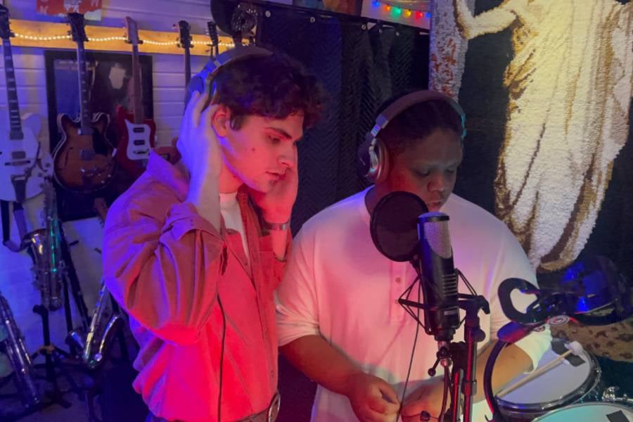 Students in the sound studio working on vocal recording.