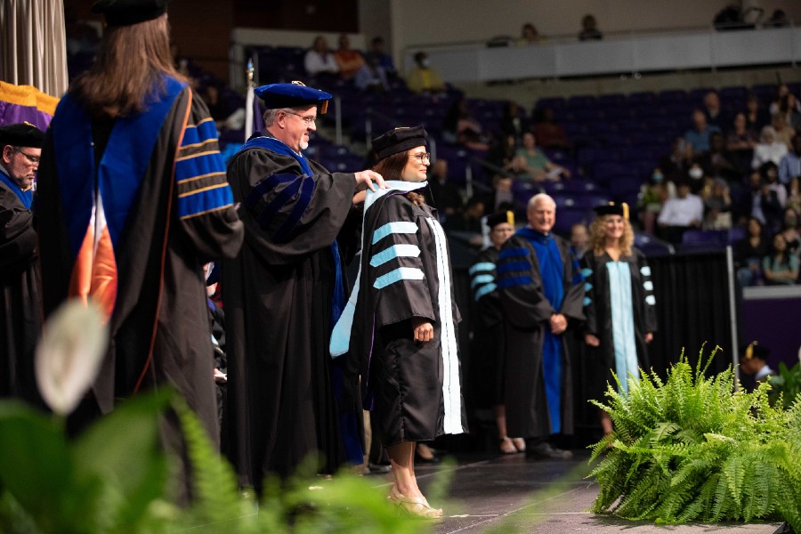 An education doctoral student getting their hood at the May 2022 commencement ceremony.