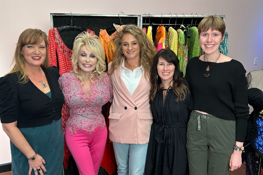 Dolly Parton posing with Lipscomb officials, her designer and Brynn Abner