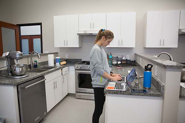 A student works on an assignment on her laptop in the nutrition lab