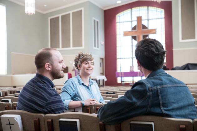 Students discussing in church pews