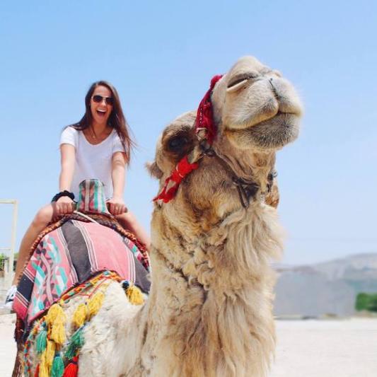 student rides a camel in Israel