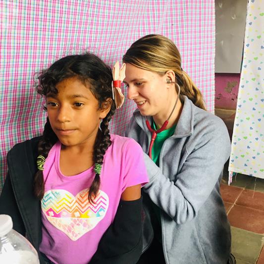 A student health professional helps a local in Honduras.