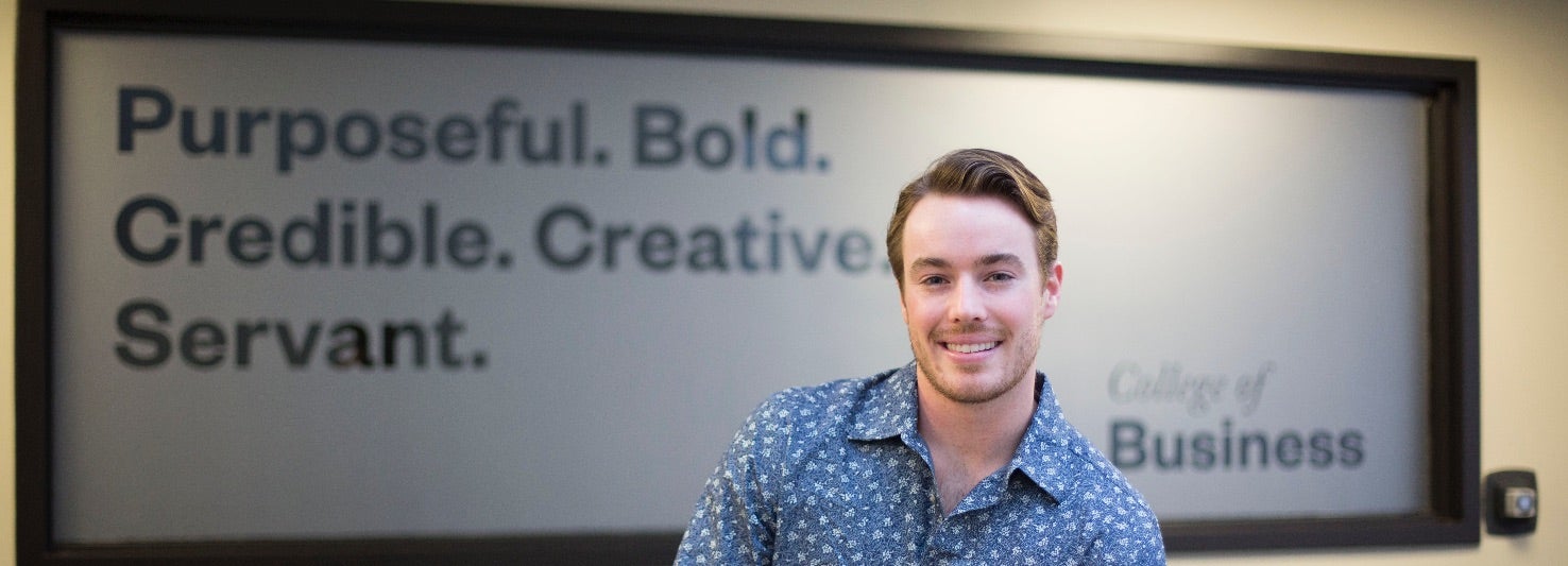 Business student in front of sign