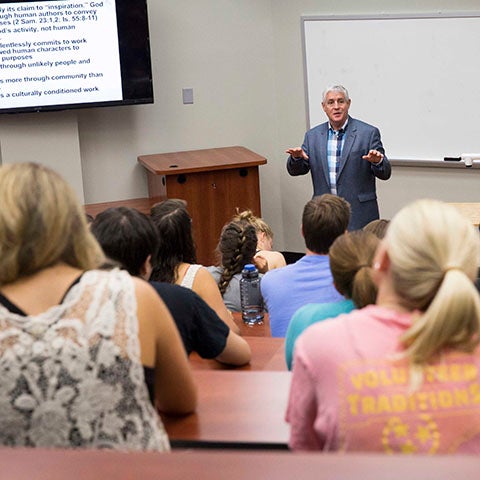 Hazelip School of Theology professor in background stands in front of class in foreground.