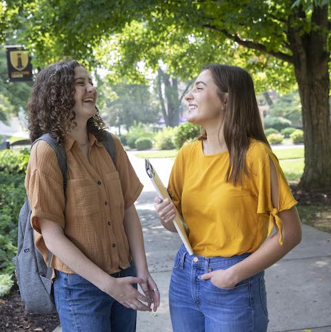 Two girls laughing on campus