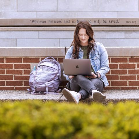 Student outside on laptop