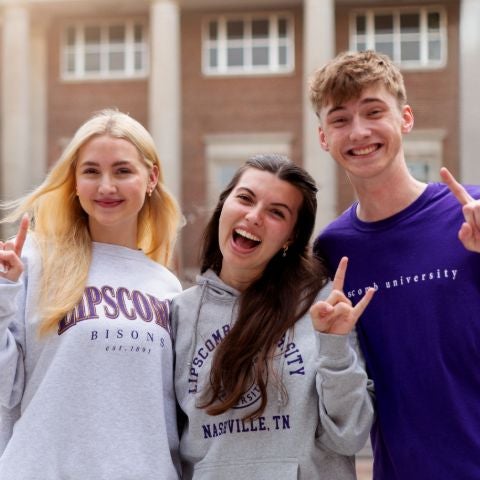 2 female students and 1 male student on campus