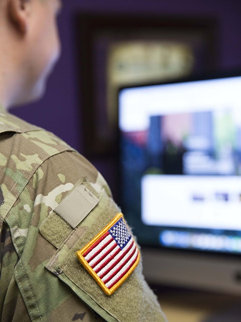 student in uniform at computer