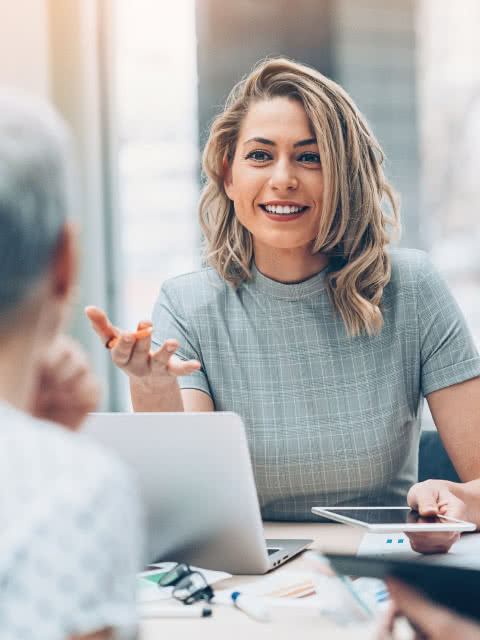 Woman speaking with laptop on table