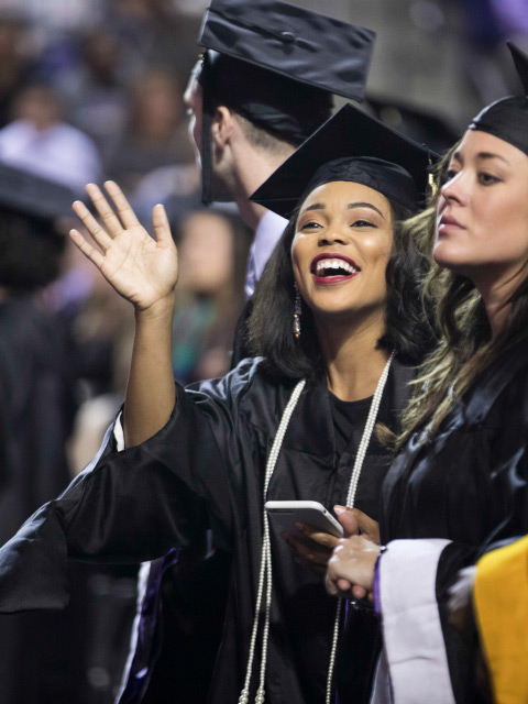Woman waves at graduation
