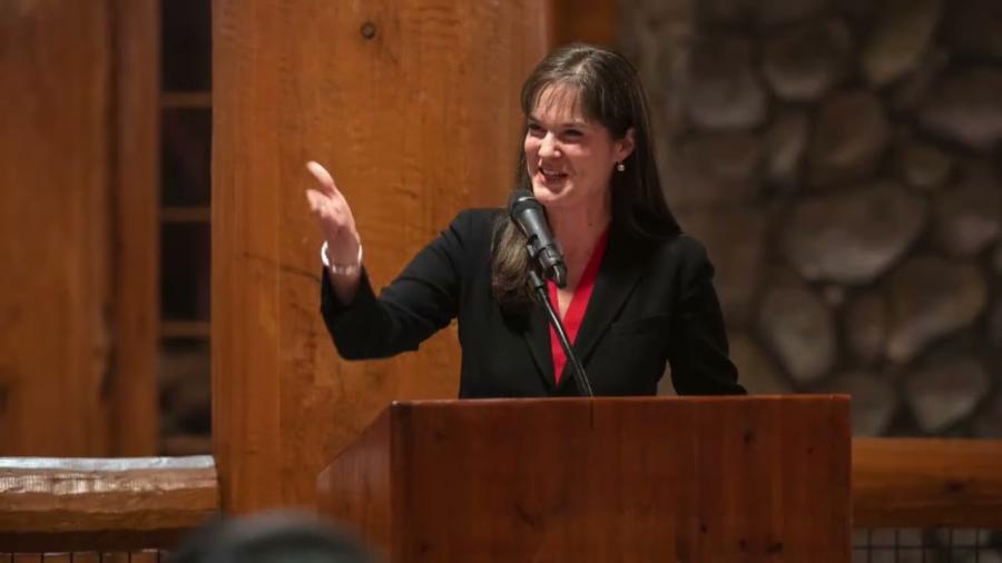 Dr. Candice McQueen signaling to the crowd at the podium