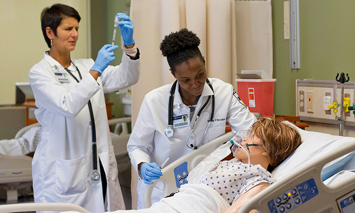 Student nurses work with a "patient".