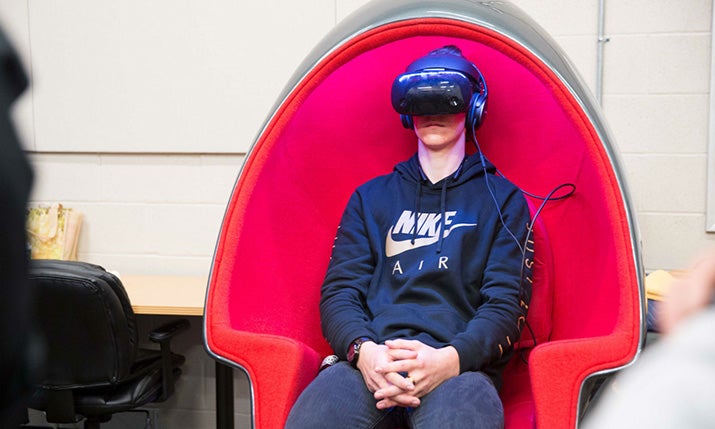 A student sits and watches in the Positron Voyager