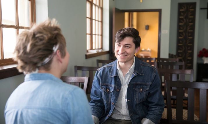 Students in pew talking facing each other