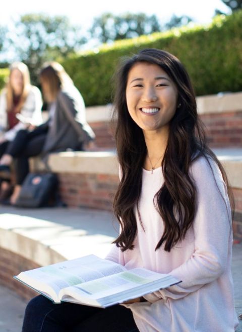 A girl smiling holding a book