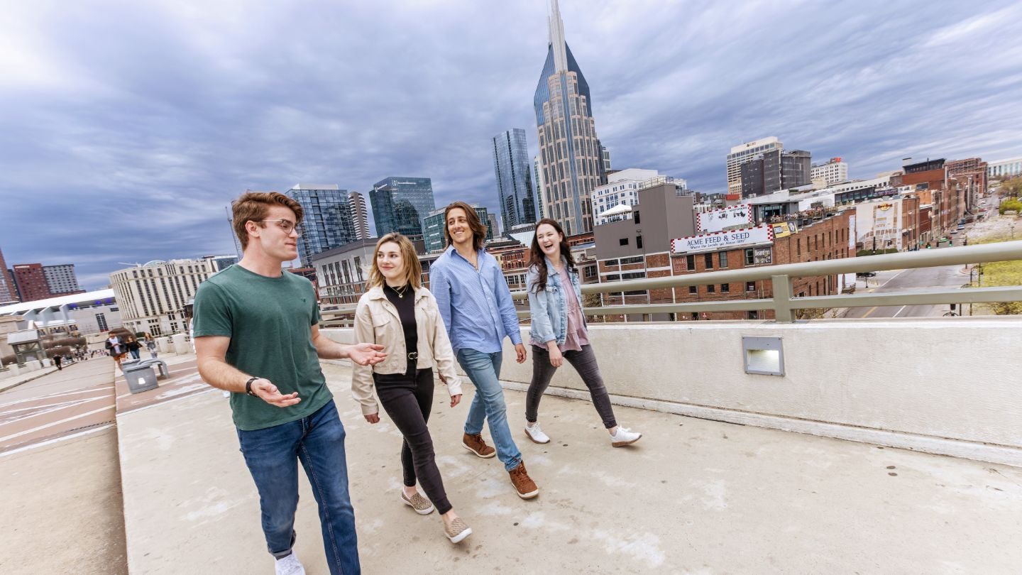 students walking by the nashville skyline