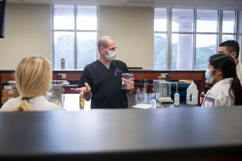 DR. JIMMY TORR, ASSOCIATE PROFESSOR OF PHARMACY PRACTICE, GIVES INSTRUCTION ABOUT THE HAND SANITIZER COMPOUNDING PROCESS.