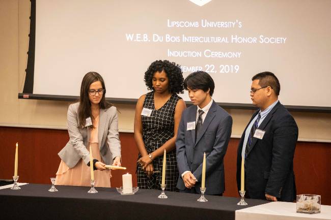 Four students at honor society induction ceremony. 