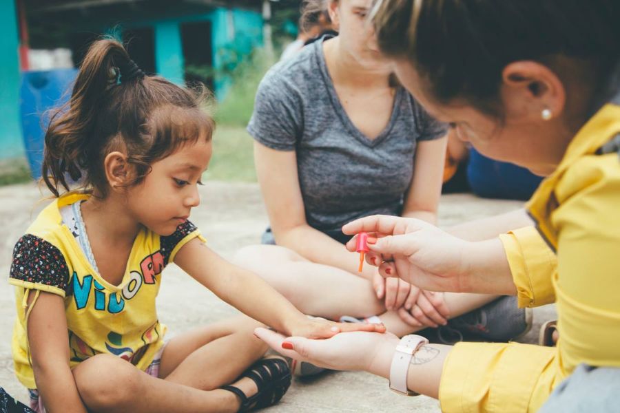 Lipscomb student painting a little girls nails 