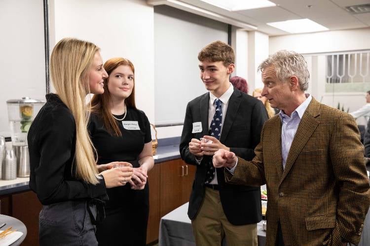 David Solomon talking to three students