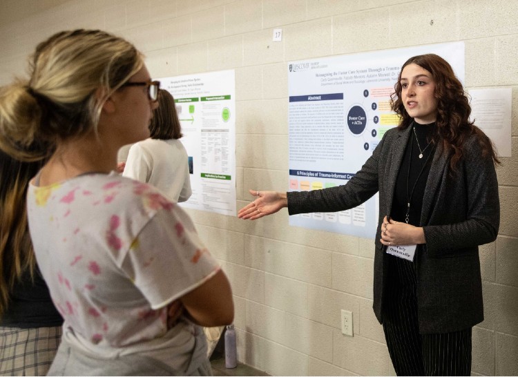 Carly Quenneville discussing poster with student