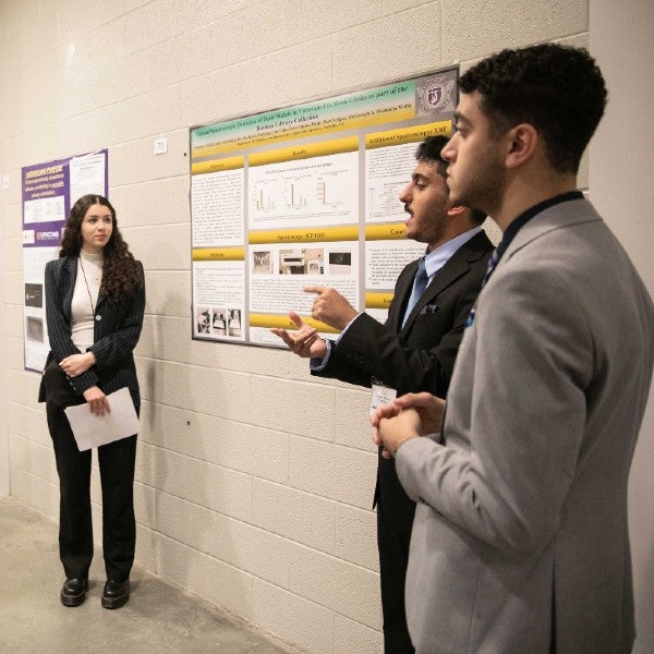 Leila Ais, Jafer Aljorani, Timothy Khalil discuss their poster presentation to viewers