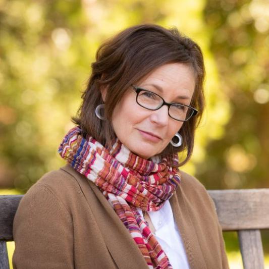 Sandra Richter in brown sweater and red scarf