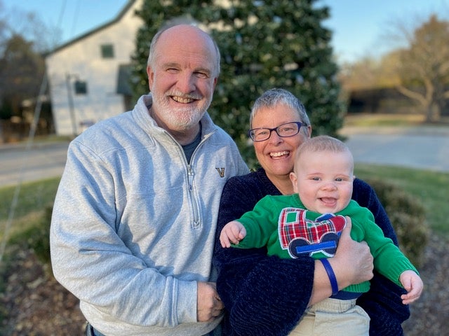 Bryan Langford standing next to his wife who is holding their grandson