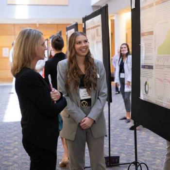 Student and professor at.the student scholar symposium