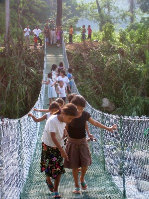 Children in the community crossing the bridge