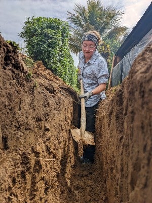 A student digging trench for water pipes