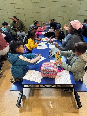 Student Jillian Utley coloring with school children