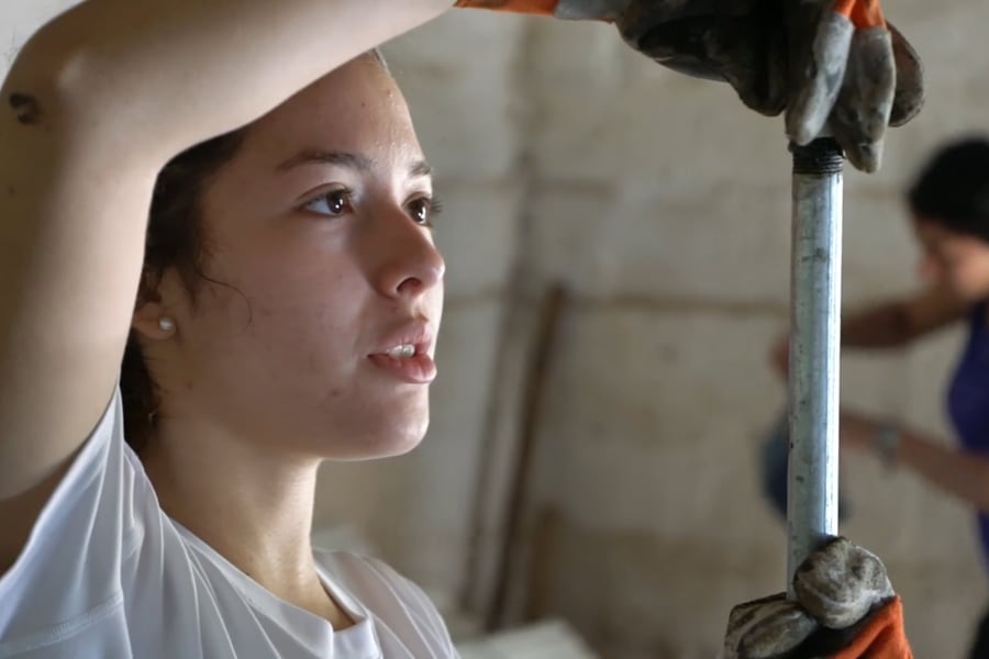 A female student examines a metal pipe