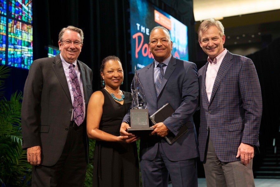 Group of four individuals holding Kopio Award