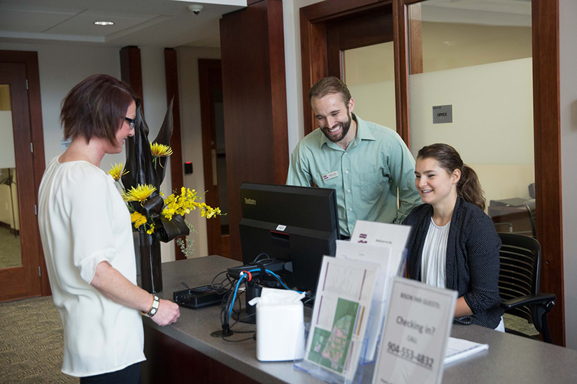 Three people at the front desk of Bison Inn