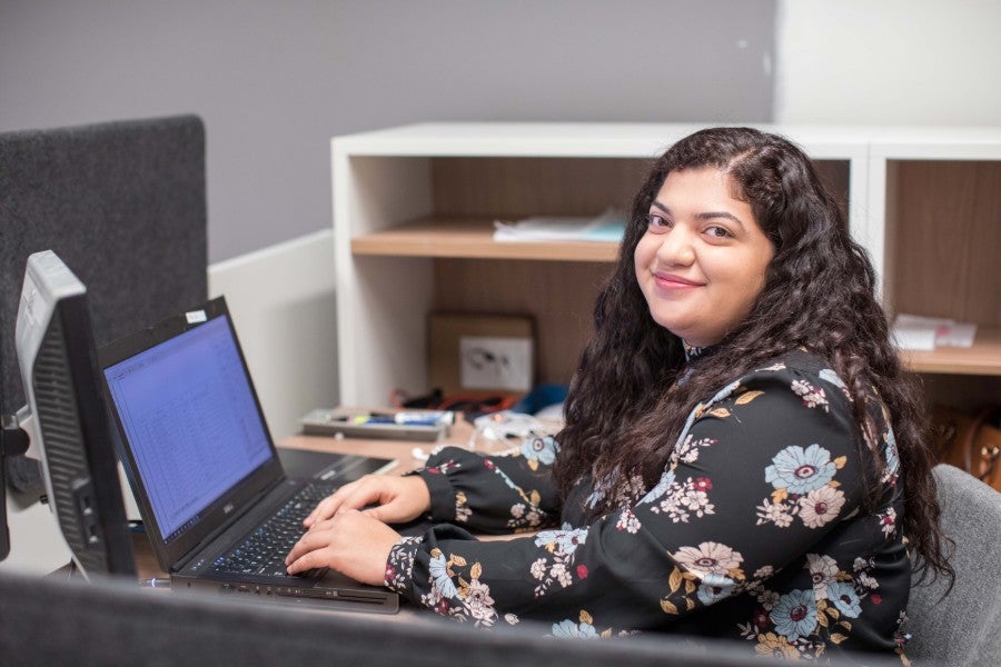 Photo of female student Meadya Doski typing on laptop computer. 