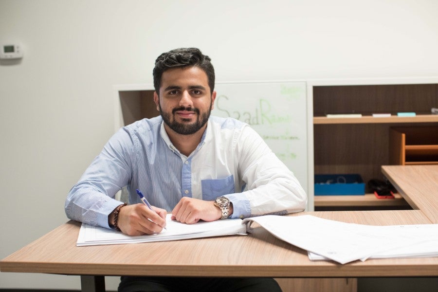 Photo of Saad Rajput sitting at a desk. 