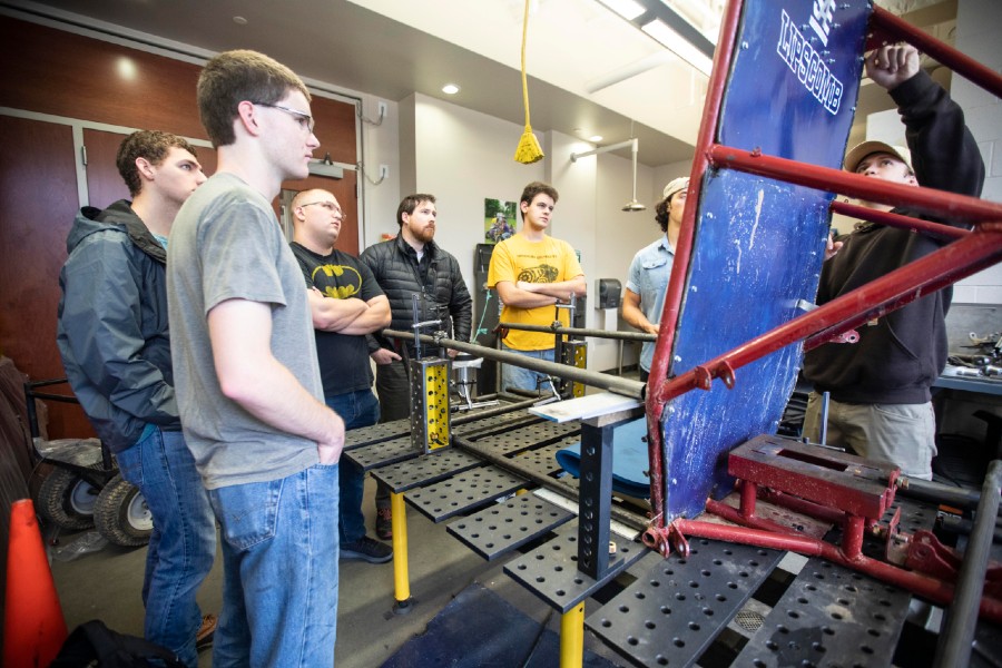 The engineering team looks over the frame for the all-terrain vehicle.