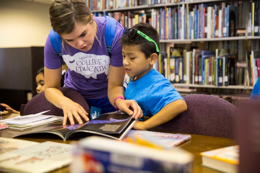 A teaching aid helping a student in the library