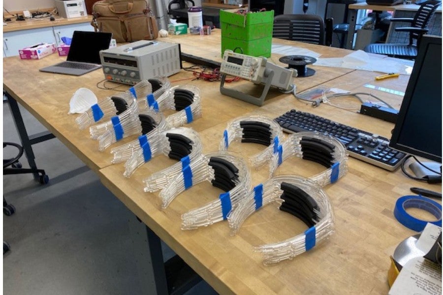 The head bands for many face shields lined up on a table