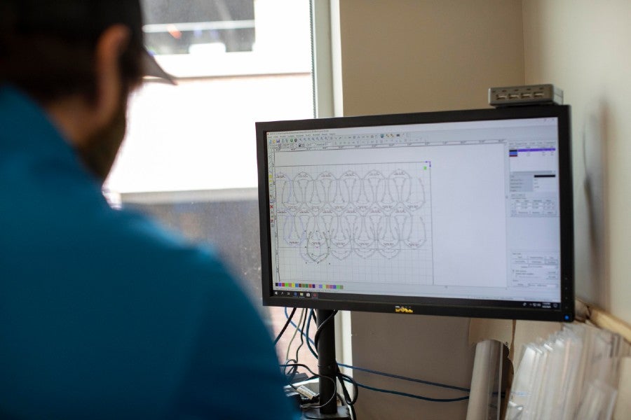 Peugeot engineers looking over the visual template for the laser cutter