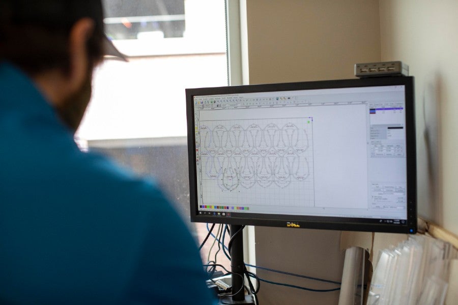 Peugeot engineers looking over the visual template for the laser cutter