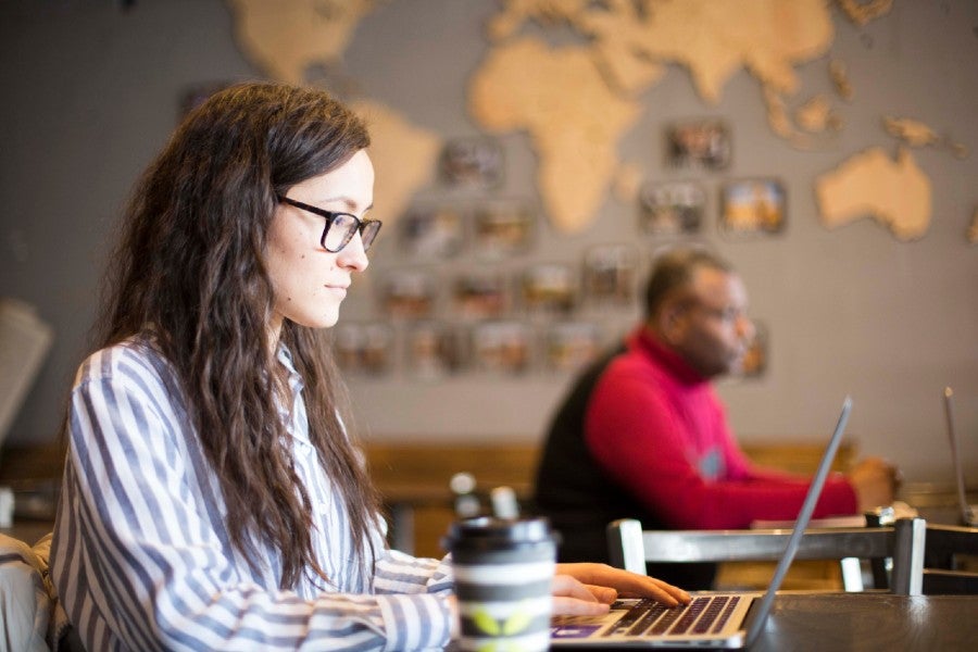 A student working on a laptop in a coffee shop